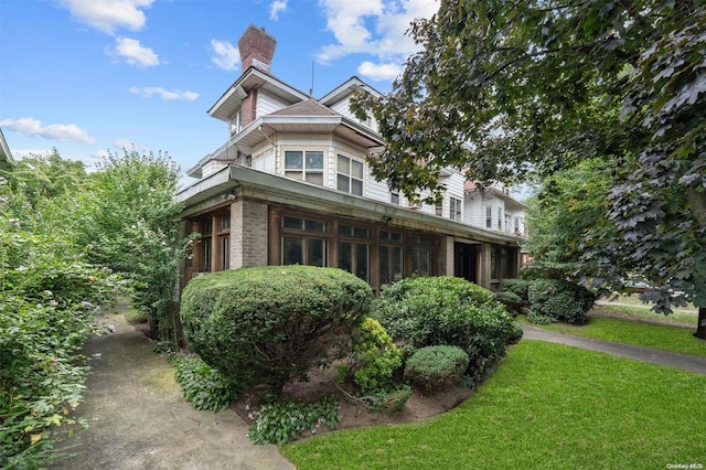 view of side of property with a lawn