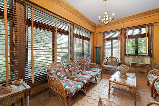 living area featuring an inviting chandelier, cooling unit, wooden walls, and crown molding