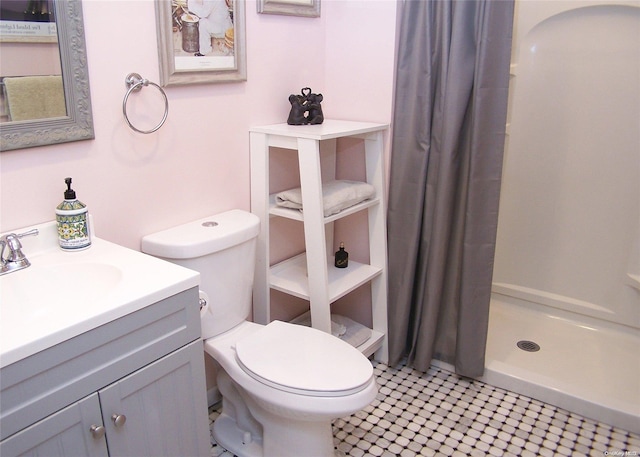 bathroom featuring a shower with shower curtain, vanity, and toilet