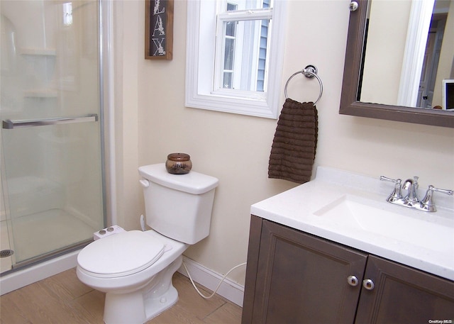 bathroom with hardwood / wood-style floors, vanity, toilet, and an enclosed shower