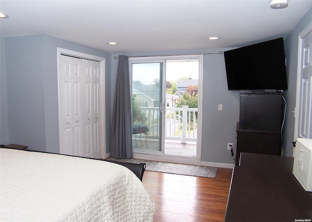 bedroom with hardwood / wood-style flooring, access to exterior, and a closet