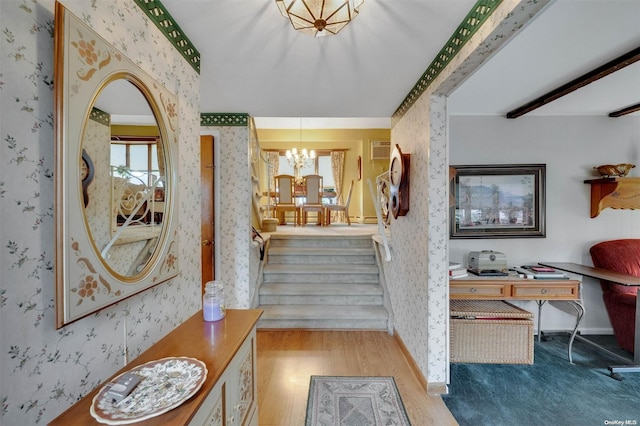 stairs with hardwood / wood-style floors, an inviting chandelier, and a wall mounted AC