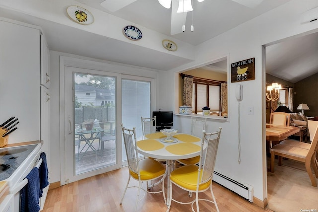 dining room featuring ceiling fan with notable chandelier, lofted ceiling, a baseboard radiator, and light hardwood / wood-style flooring