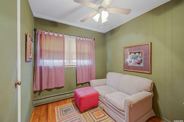 sitting room with ceiling fan, light hardwood / wood-style flooring, and a baseboard radiator