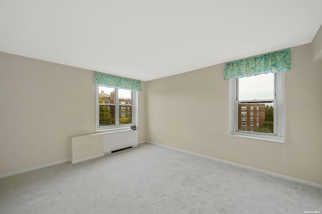 unfurnished room featuring a wealth of natural light and light carpet