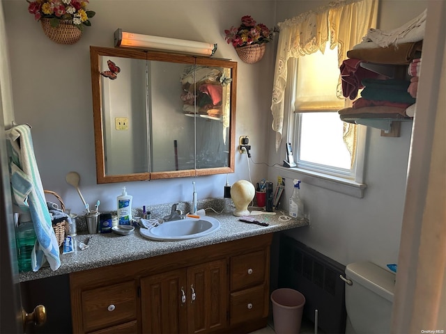 bathroom featuring vanity, toilet, and radiator heating unit