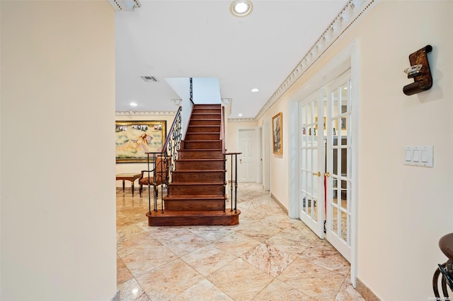 entryway with crown molding and french doors