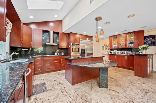 kitchen featuring appliances with stainless steel finishes, sink, pendant lighting, a kitchen island, and a breakfast bar area