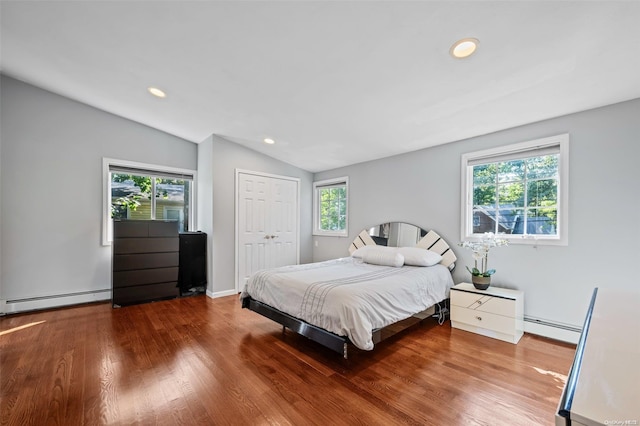 bedroom with lofted ceiling, baseboard heating, and multiple windows