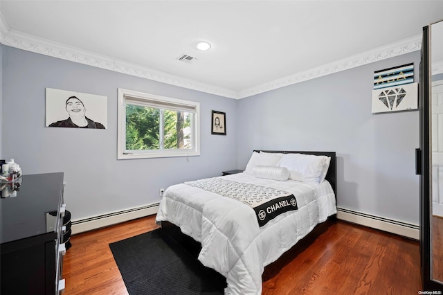 bedroom with dark hardwood / wood-style floors, crown molding, and a baseboard heating unit