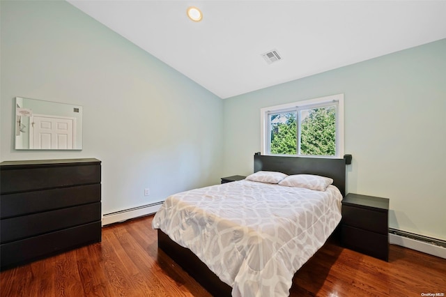 bedroom featuring hardwood / wood-style flooring, vaulted ceiling, and a baseboard radiator