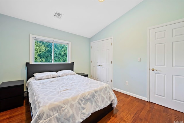 bedroom with dark wood-type flooring, a closet, and lofted ceiling