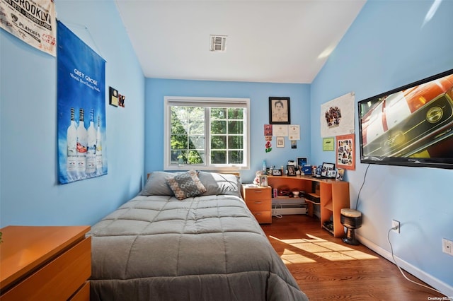 bedroom featuring hardwood / wood-style floors and lofted ceiling