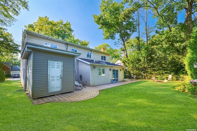 back of house with a yard and a patio