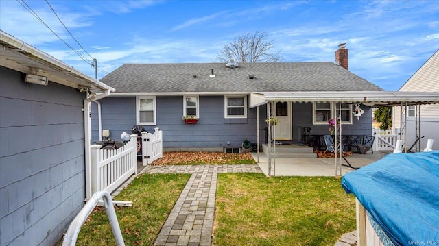 back of house with a lawn and a patio