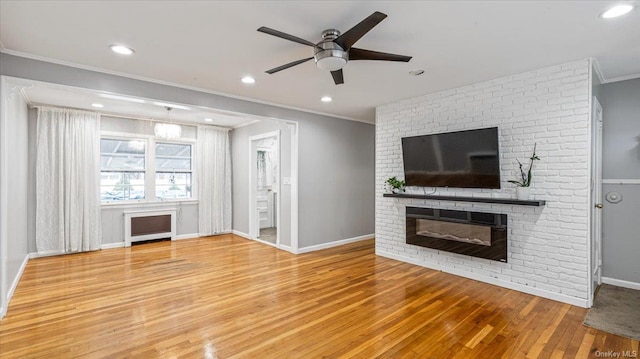 unfurnished living room featuring crown molding, a fireplace, ceiling fan, and wood-type flooring