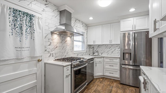 kitchen with wall chimney range hood, sink, appliances with stainless steel finishes, dark hardwood / wood-style flooring, and white cabinetry