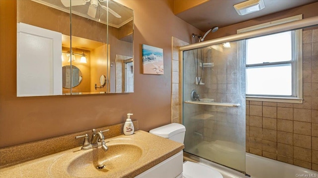 full bathroom featuring shower / bath combination with glass door, ceiling fan, vanity, and toilet