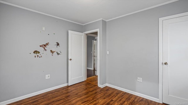 empty room with dark hardwood / wood-style floors and crown molding