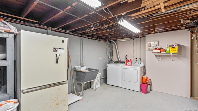 basement featuring washer and dryer and white refrigerator