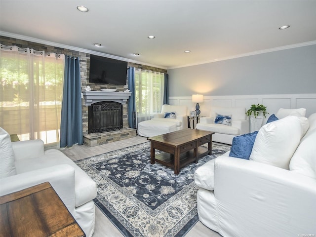 living room featuring crown molding, a fireplace, and wood-type flooring