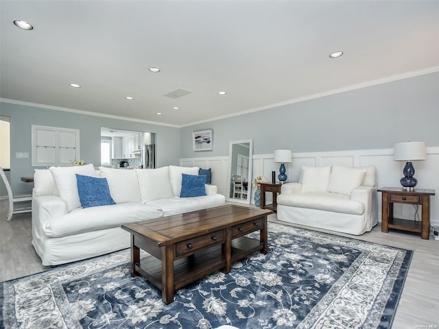 living room with wood-type flooring and crown molding