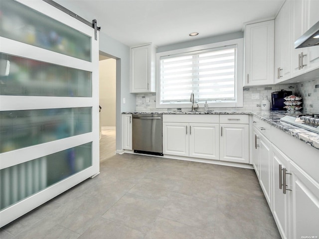 kitchen featuring dishwasher, a barn door, white cabinets, and sink