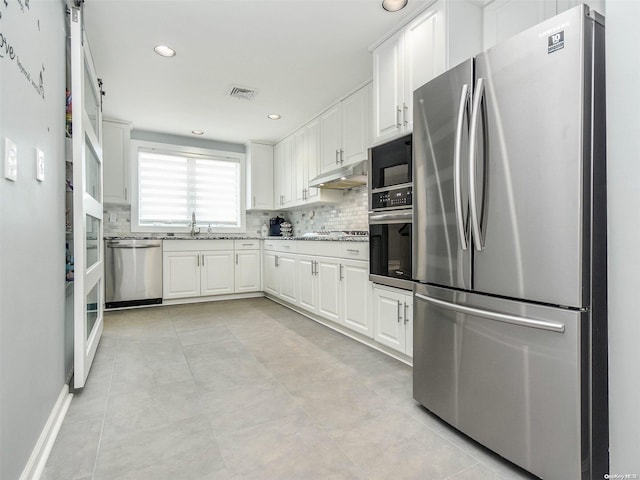 kitchen featuring decorative backsplash, white cabinetry, sink, and appliances with stainless steel finishes