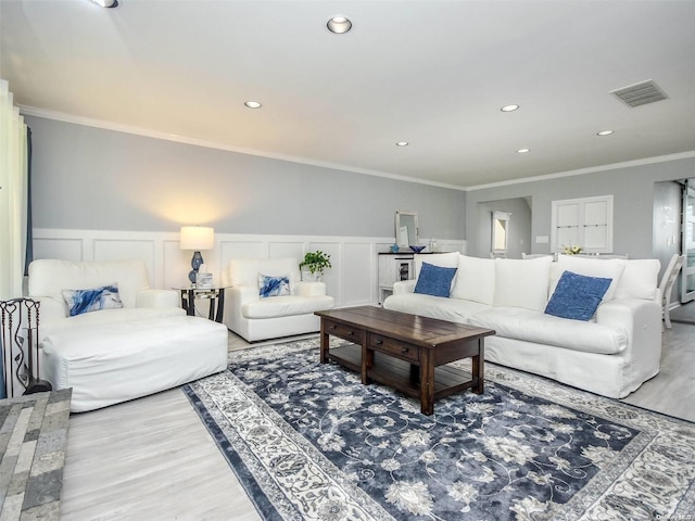 living room featuring wood-type flooring and crown molding