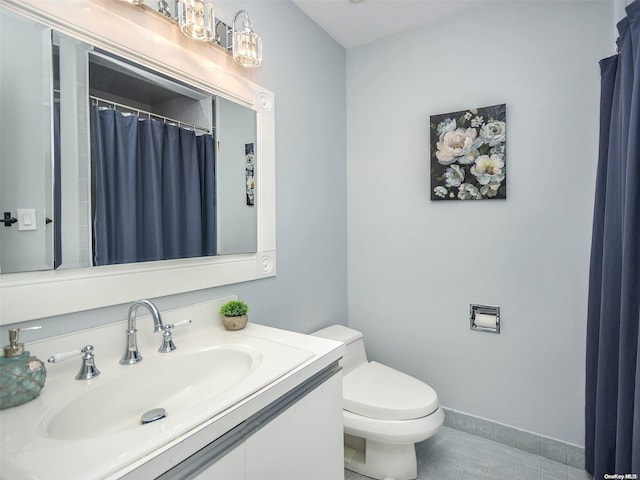 bathroom featuring tile patterned flooring, vanity, and toilet