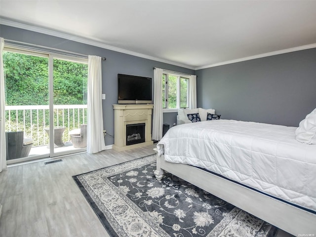 bedroom featuring access to outside, crown molding, and hardwood / wood-style floors