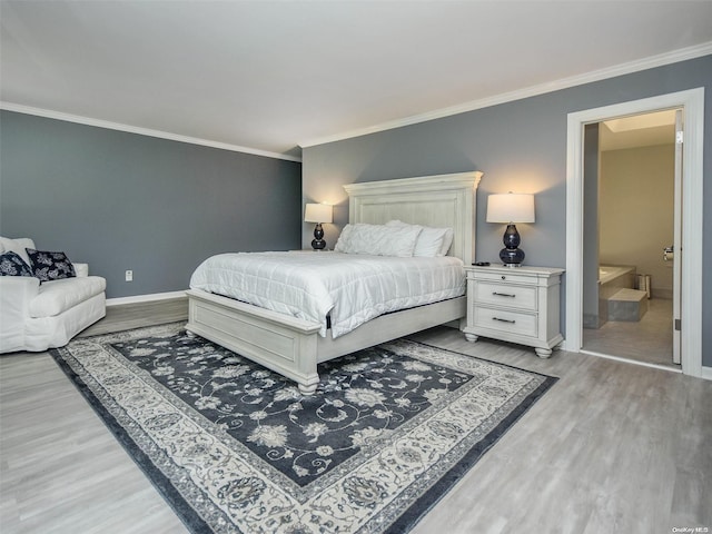 bedroom with light hardwood / wood-style floors, ensuite bath, and ornamental molding