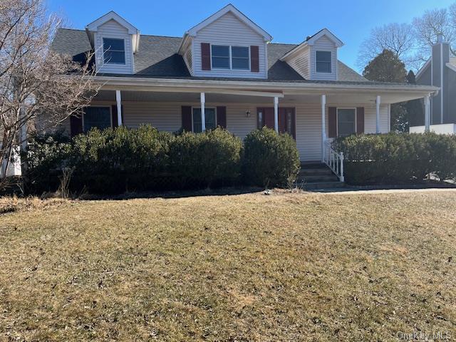 view of front of property with a porch and a front lawn