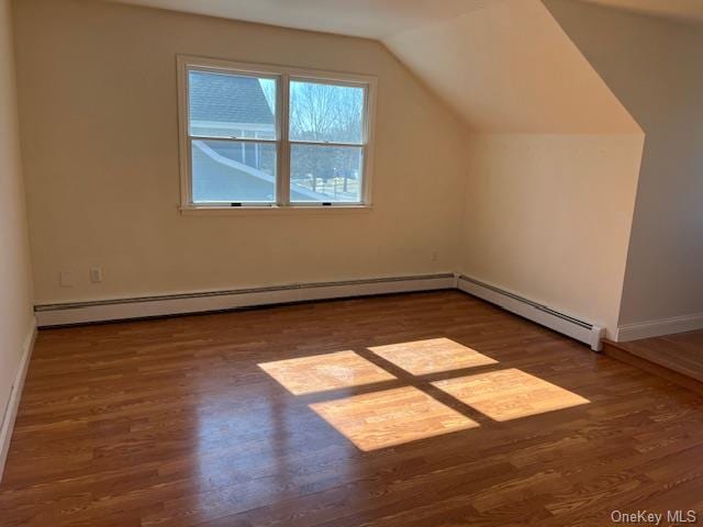 additional living space with vaulted ceiling, baseboard heating, wood finished floors, and baseboards