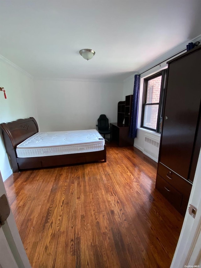 bedroom featuring wood-type flooring and radiator