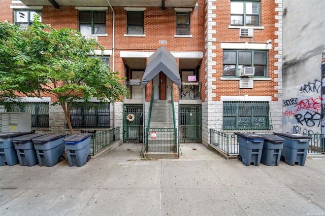 view of building exterior with cooling unit and fence