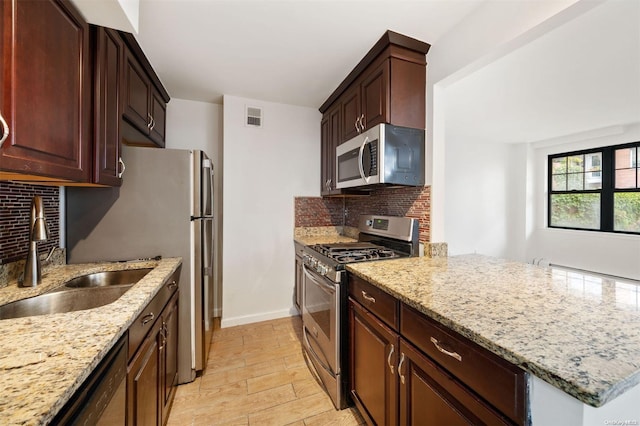 kitchen featuring visible vents, backsplash, appliances with stainless steel finishes, and a sink