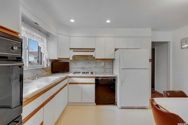 kitchen featuring black appliances, decorative backsplash, white cabinets, and sink