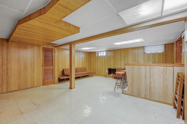 basement with wood walls and bar area