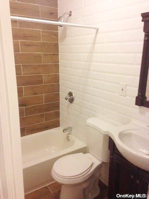 full bathroom with tiled shower / bath combo, toilet, and vanity