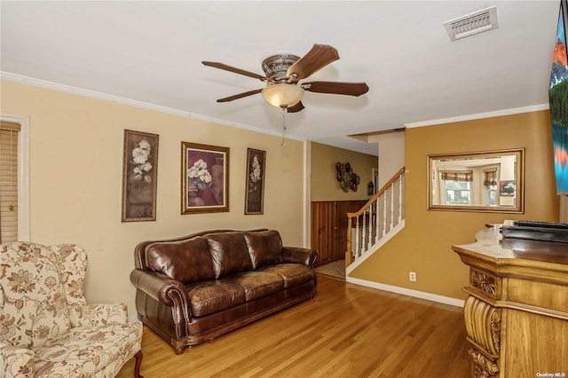 living room featuring hardwood / wood-style floors, ceiling fan, and ornamental molding