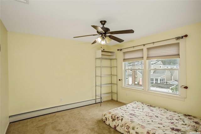 bedroom with ceiling fan, light colored carpet, and a baseboard heating unit