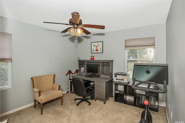 carpeted office with plenty of natural light and ceiling fan