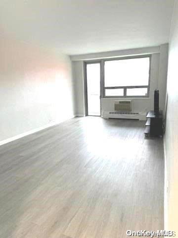 unfurnished room with hardwood / wood-style floors and a wall mounted AC