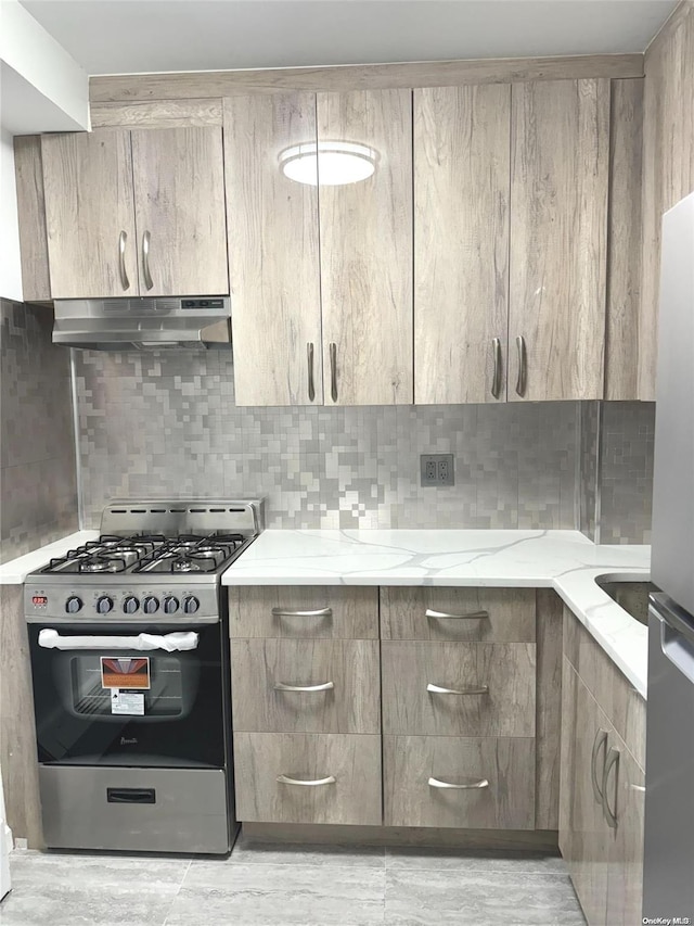 kitchen with light stone countertops, decorative backsplash, and stainless steel appliances