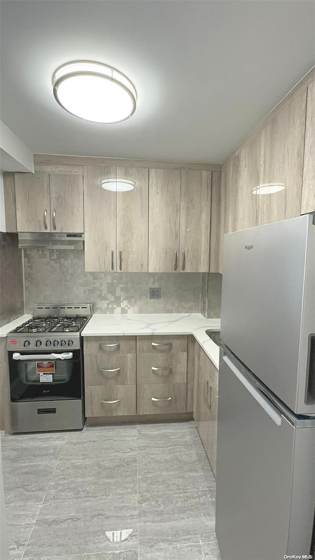 kitchen with backsplash, light brown cabinetry, and appliances with stainless steel finishes