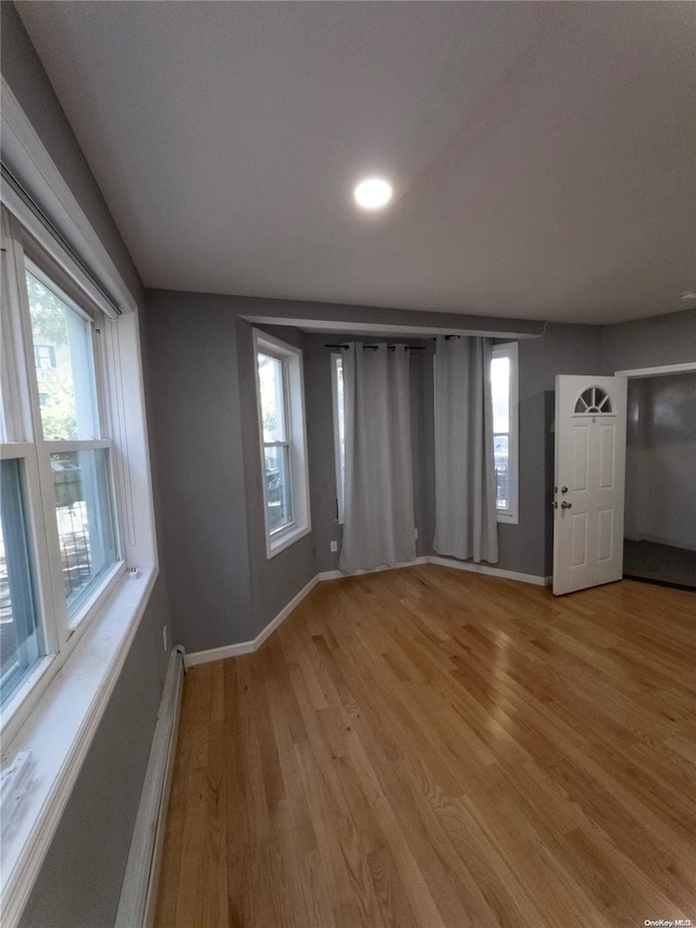 interior space featuring baseboard heating and hardwood / wood-style flooring