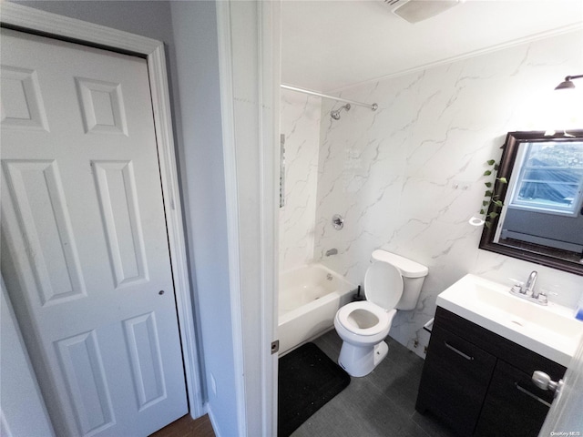 full bathroom with vanity, toilet, tiled shower / bath, and tile walls