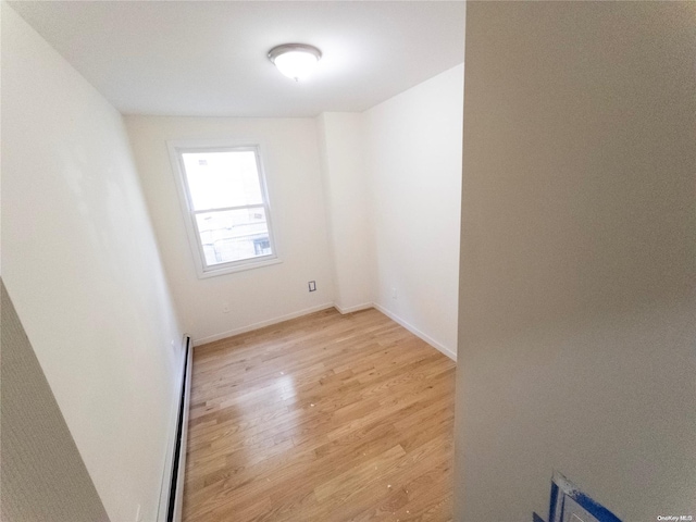 spare room featuring light hardwood / wood-style floors and a baseboard heating unit