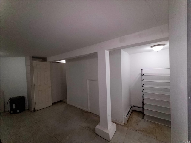 basement featuring tile patterned flooring and a baseboard radiator